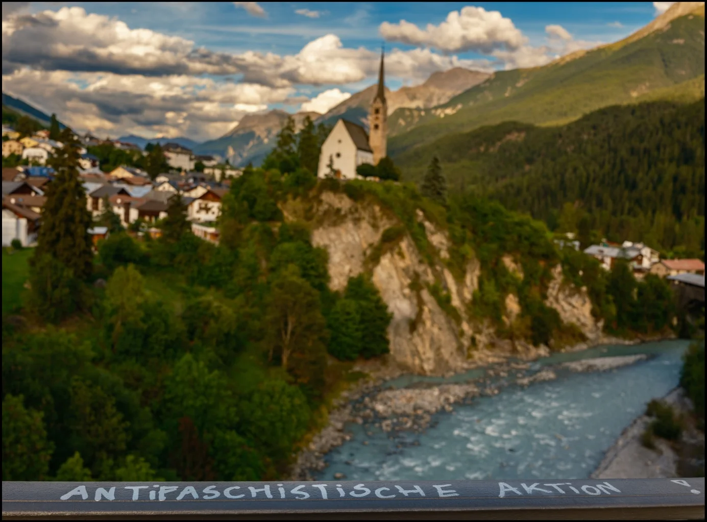 Landschaft im Engadin mit Kirche, Fluss und Bergen, aufgenommen mit unscharfem Hintergrund bei Blende f/8 | Excire