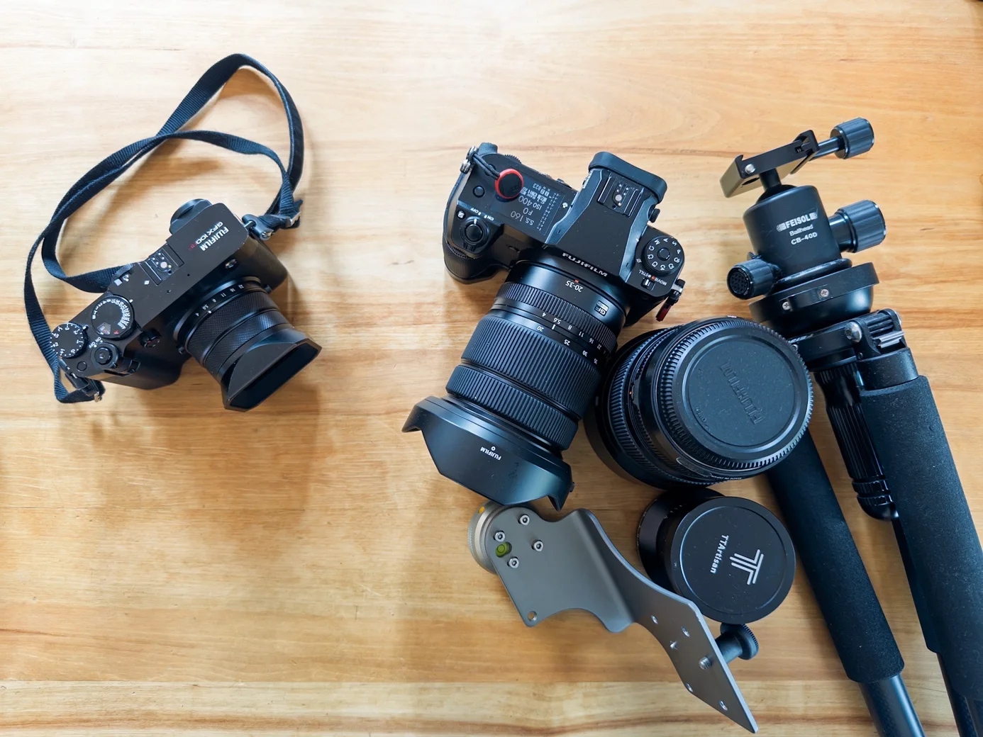 Zwei Kameraausrüstungen für Landschaftsfotografie: links leichtes Setup, rechts Kamera mit Objektiven und Stativ | Excire