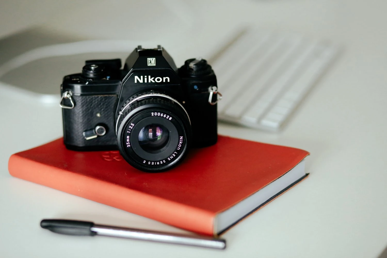A Nikon film camera on a red journal.